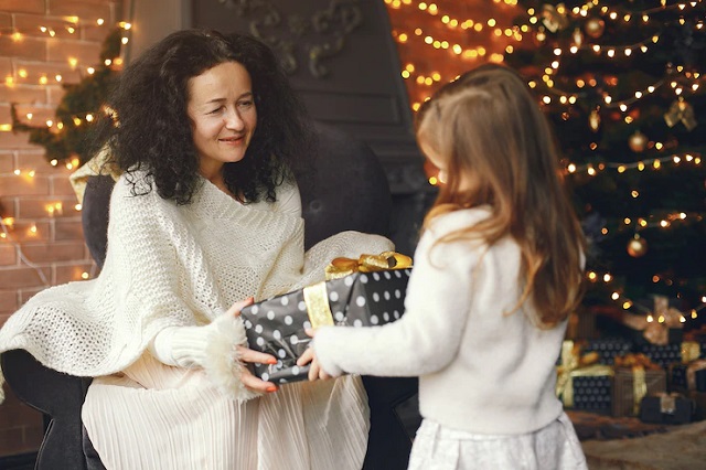  une petite fille offrant un cadeau pour sa grand mère